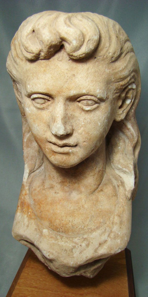 Roman, an exquisitely rendered marble head: Roman, c. 100-300AD., a wonderfully carved smaller than life size marble head of a young girl. Her delicate facial features are extremely realistic as is her long flowing hair that hangs on her forehe