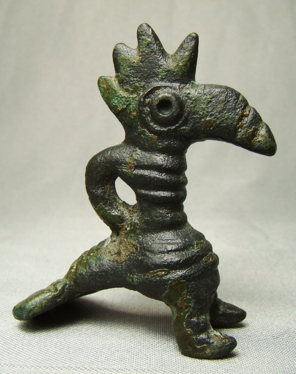 Roman, small and finely crafted bronze rooster: Roman, c. 100BC-300AD, a small and finely crafted bronze rooster. Rooster stands on tripod legs consisting of on his 2 legs and tail feathers. Tall comb with loop behind his neck for hanging. H: 1.5".