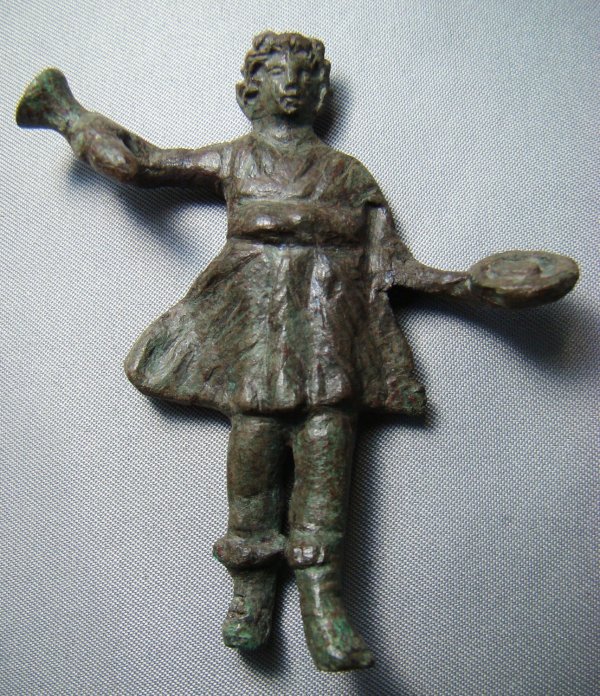 Roman, choice small bronze figure of Lar: Roman, 200-300AD, a nice and choice small bronze figure of Lar. He stands with his left arm outstretched and holding a patera, his right arm held upwards and holding a rhython. Choice detail to the fa