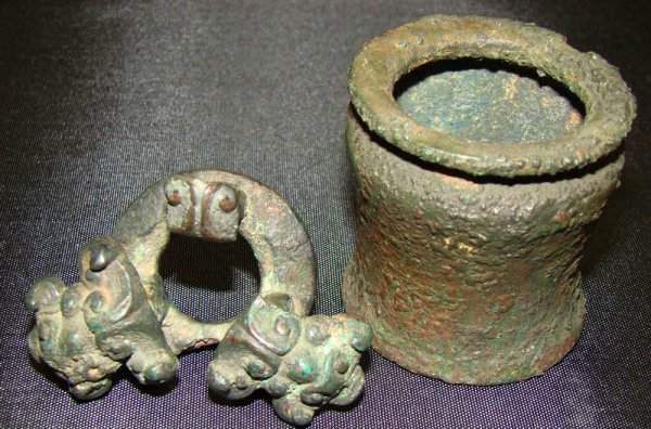 Greek, c. 500BC, a lot of 2 small bronzes!: Greek, c. 500BC, a small bronze cup or beaker of cylindrical shape. Small chip to rim. Nice patina. Height and diameter are about 2". Also from ancient China(?), an unusual appliqué with 3 highly sty