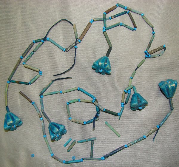 Egypt, a single broken beaded necklace strand: Egypt, Late Period, 20th-30th Dynasties, 715-332BC., a single broken necklace strand consisting of mostly tubular shape blue faience "mummy" beads and highlighted with ribbed bell shaped faience amule