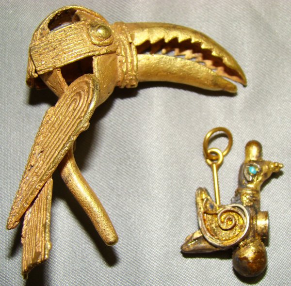 A lot of 2 faux gold pendants of uncertain origin.: A lot of 2 faux gold pendants of uncertain origin. The first piece is a Pre-Columbian(?) toucan that measures 2" in length and is choice. Also a middle eastern small bird with inlaid turquoise eyes. L
