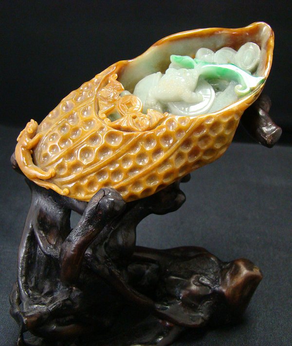 China, an exquisite jade slipper, c. late 20th: China, an exquisite jade slipper, c. late 20th century. A rare three colored jadeite carving in shades of brown, dark green, and light green that has been whimsically carved into a slipper filled with
