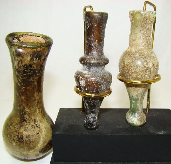 Roman, c. 100-300AD., lot of 3 nice small flasks: Roman, c. 100-300AD., a lot of 3 nice small glass bottles. The largest is "tear" vial shaped and with attractive dark green iridescence. H: 3.5". Also a pair of decorative bottles, one green and 3", t