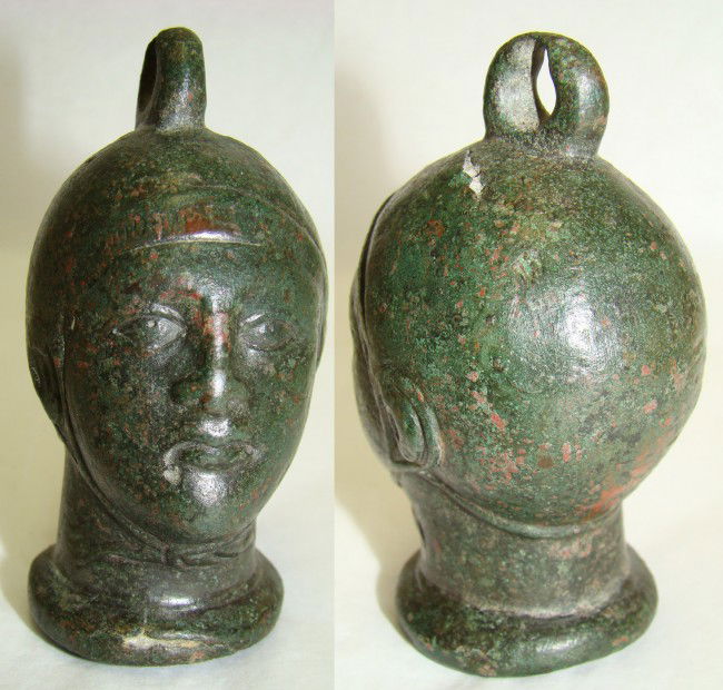 Roman, STEELYARD WEIGHT IN FORM OF WRESTLER'S HEAD: Roman, 3rd-4th century AD., a choice bronze steelyard weight in the form of a helmeted young wrestler's head with loop on top. Excellent and well defined with realistic facial features. He wears a smo