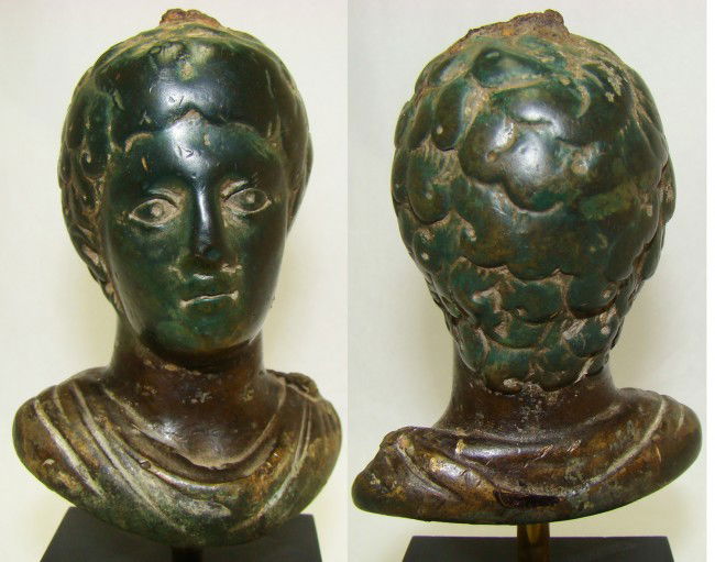 Roman, CHOICE STEELYARD FIGURAL OF A YOUNG BOY: Roman, 3rd-4th century AD., a choice bronze figural steelyard weight in the form of a young boy. He appears to be gazing off into the distance with his large round eyes. His hair is represented in lar