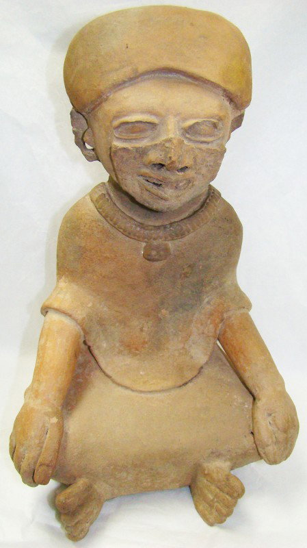 Mexico, Veracruz, tall and choice seated priest: Mexico, Veracruz, c. 250-550AD., a tall and choice seated priest in a pale brown slip. Priest sits wearing a thick necklace with pendant, his legs are crossed as he wears long gown and draped shirt. H
