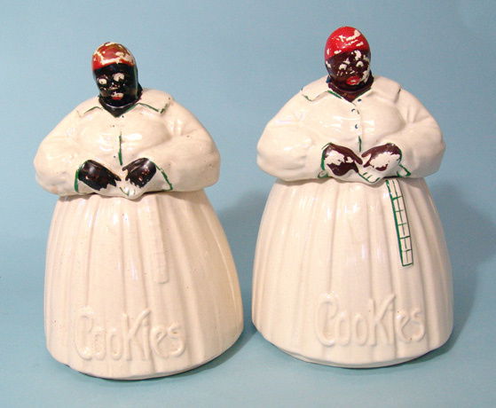 A pair of identical "Aunt Jemima" porcelain cooki: A pair of identical "Aunt Jemima" porcelain cookie jars with Mc Coy marking on bottom and "Cookies" embossed on bottom front. Jemima is clad in long white dress with red scarf on head. Both G with som