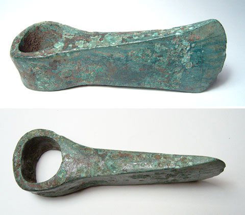 A Roman Egyptian Bronze Socketed Axe Head: Roman Egypt, c.1st Century AD. A bronze socketed axe-head. Intact and substantial with an attractive olive green patina. L: 5 ¾". See Petrie, Tools and Weapons, pl. XIII, 31-32. Ex Leighton Wilkie co