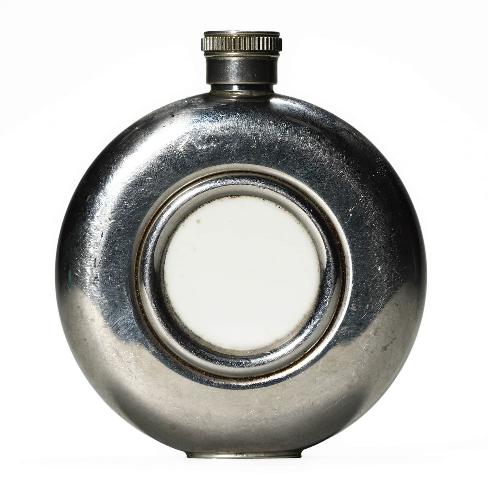 A STAINLESS STEEL AND GLASS ROUND HIP FLASK: Dimensions: Height: 4 1/8 in. (10.5 cm), Width: 3 1/2 in. (9 cm) Description: This vintage round hip flask is crafted from polished stainless steel with a central circular glass inset on both sides. T