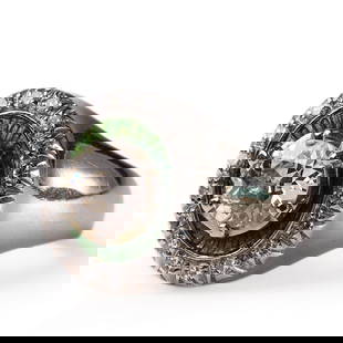 18K GOLD DIAMOND RING WITH GREEN ENAMEL ACCENTS: Dimensions: Face diameter: 1/4 in. (6.4 mm), Inner diameter: 11/16 in. (17.6 mm), Weight: 7.9 g This striking 18K gold ring features a brilliant-cut central diamond encircled by a vibrant green enamel