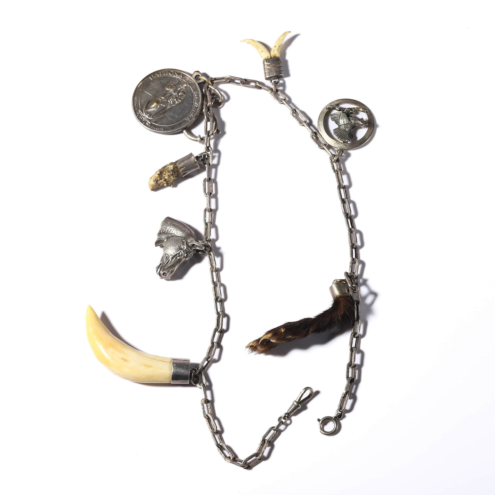 GERMAN, BAVARIA, 20TH CENTURY — TRADITIONAL LADIES’ CHARIVARI JEWELRY.: GERMAN, BAVARIA, 20TH CENTURY — TRADITIONAL LADIES’ CHARIVARI JEWELRY. Medium: Silver with animal tooth, fur, coin, and hunting charms?Dimensions: Length: 21 1/4 in. (54 cm); Weight: 101 g. Descri