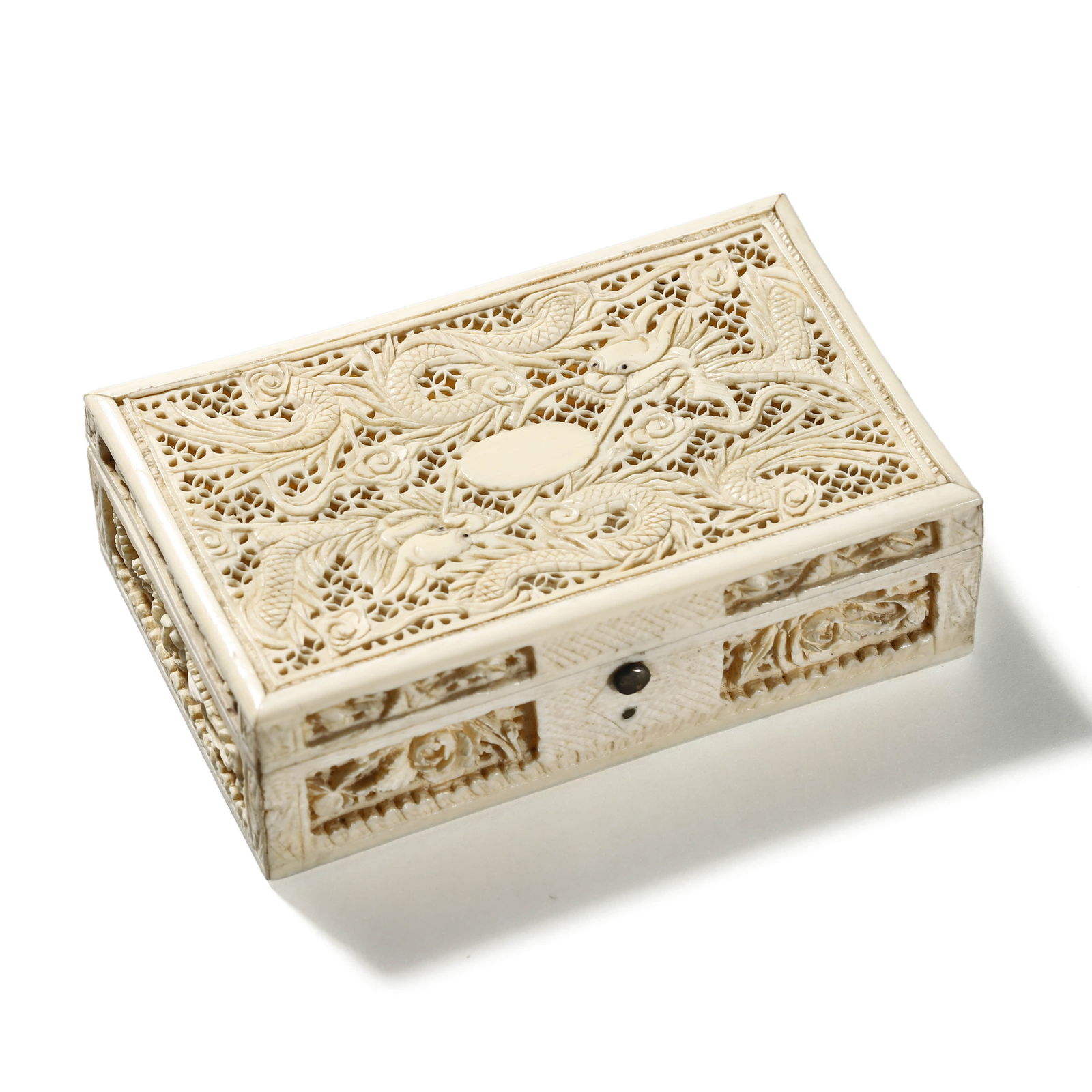 ANTIQUE CHINESE CARVED BONE BOX: Dimensions: Length: 4 in. (10.1 cm), Width: 2 7/16 in. (6.2 cm), Height: 1 3/16 in. (3 cm). Description: A finely carved Chinese bone box with intricate openwork panels depicting phoenixes, dragons, a
