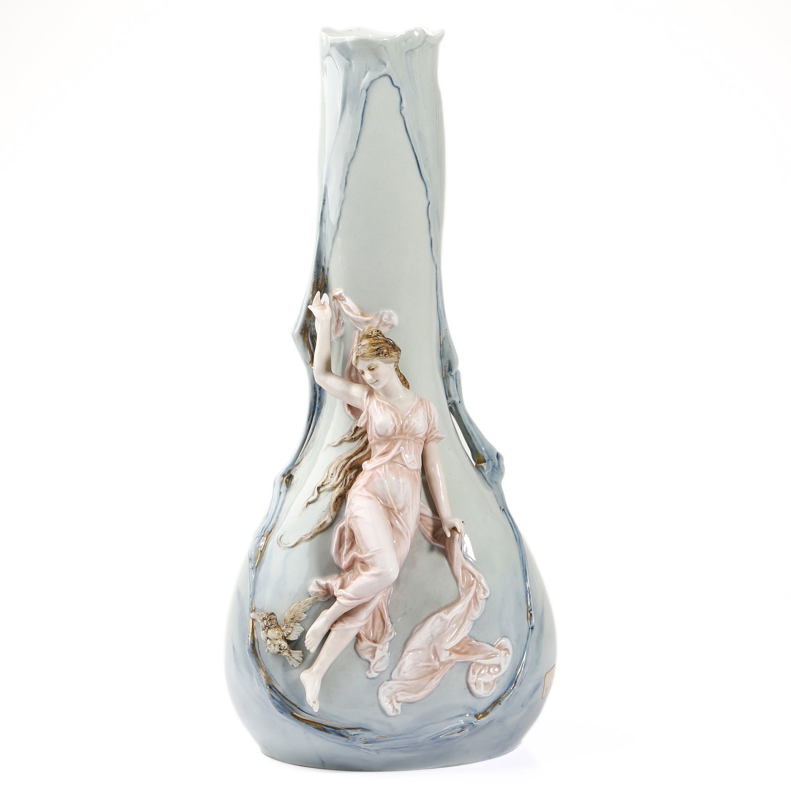 AN ART NOUVEAU PORCELAIN VASE: Dimensions: Height: 13 3/4 in. (35 cm) Description: An Art Nouveau porcelain vase of elongated form, finely modeled in high relief with a draped female figure holding a flowing scarf, rendered in
