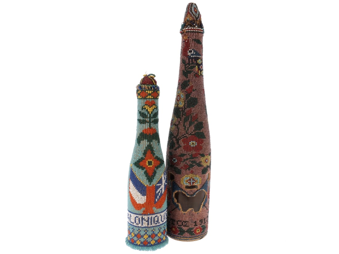 Pair of Beaded Bottles: Pair of Beaded Bottles. 6.5cm x 33 cm. Covered in vines and flowers with a name in Cyrillic and dated 1913. Part of the canvas and beadwork has been cut away. Beads are loose around the cut out