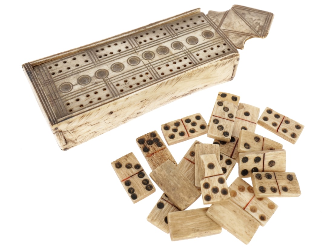 Small Bone Cribbage Board with Dominos: Small Bone Cribbage Board with Dominos. Cribbage board acts as a storage box for 20 dominos, 1.1cm x 2cm. Some are damaged. Box measures 9.2cm x 3.5cm x 2cm with the lid measuring 12.6cm long. Lid