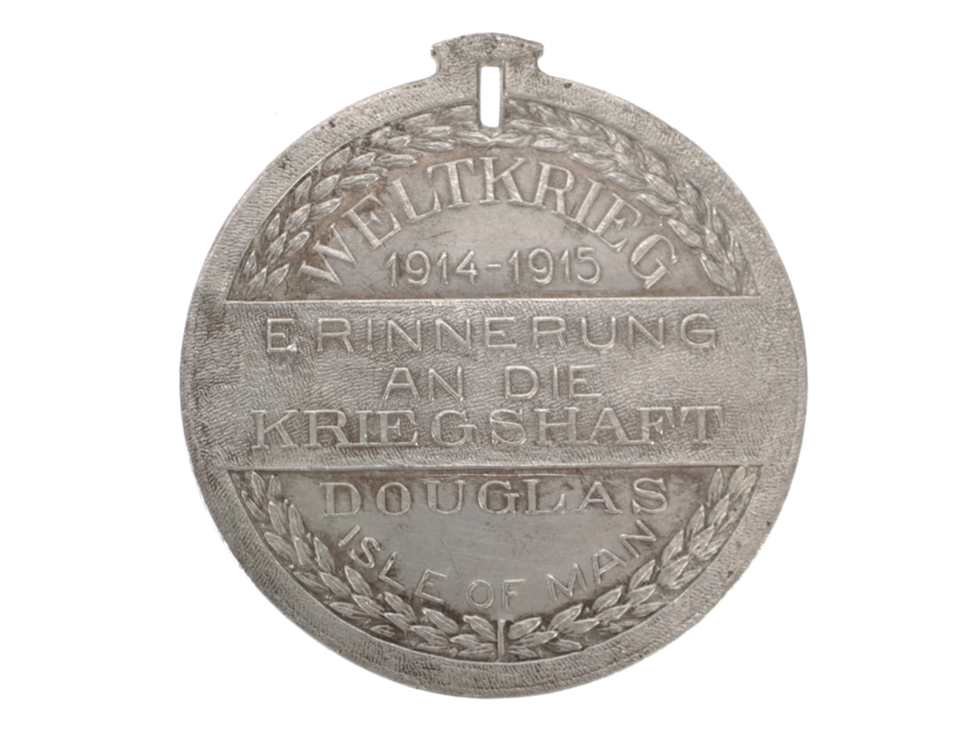 WWI German POW Made Souvenir Medal - Douglas: WWI German POW Made Souvenir Medal - Douglas 45mm diameter non-magnetic white metal. The image on the front depicts a camp of tents and barracks buildings with the Tower of Refuge and Douglas Head Lig
