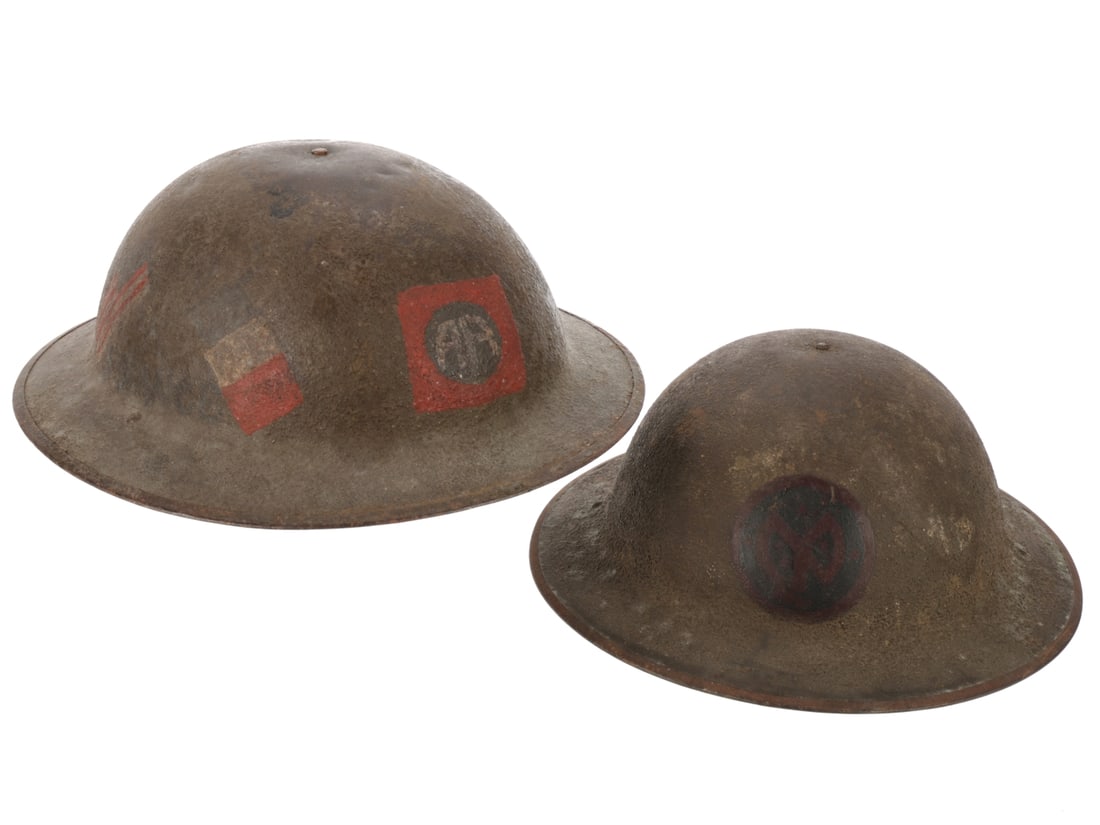 WWI US 82nd Division and 27th Division Painted Helmets: WWI US 82nd Division and 27th Division Painted Helmets. Both US M1917 helmets. First features 82nd Division painted insignia on the front, crossed US and French flags on one side. Interior has liner a