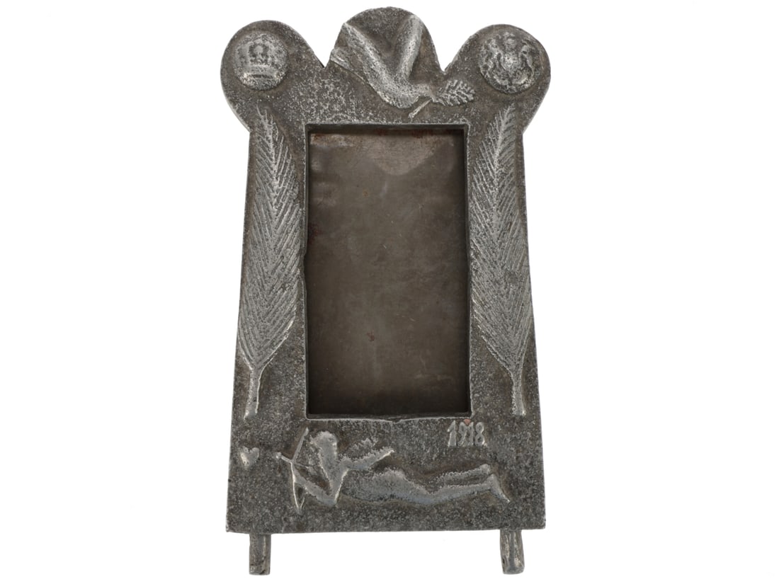 Armistice Frame: Armistice Frame. Roughly cast aluminum frame with a Peace Dove at the center top and German and British General Service button in the corners. 2.5" x 4.5" opening is flanked by palm leaves and the tal
