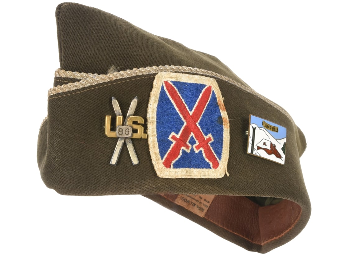 US WWII Cap with 10th Mountain Division Insignia and Crossed Skis 86th Infantry Regimental Pin: US WWII Cap with 10th Mountain Division Insignia and Crossed Skis 86th Infantry Regimental Pin. US WWII enlisted garrison cap of olive drab wool elastique has (faded) blue Infantry piping. This cap ha