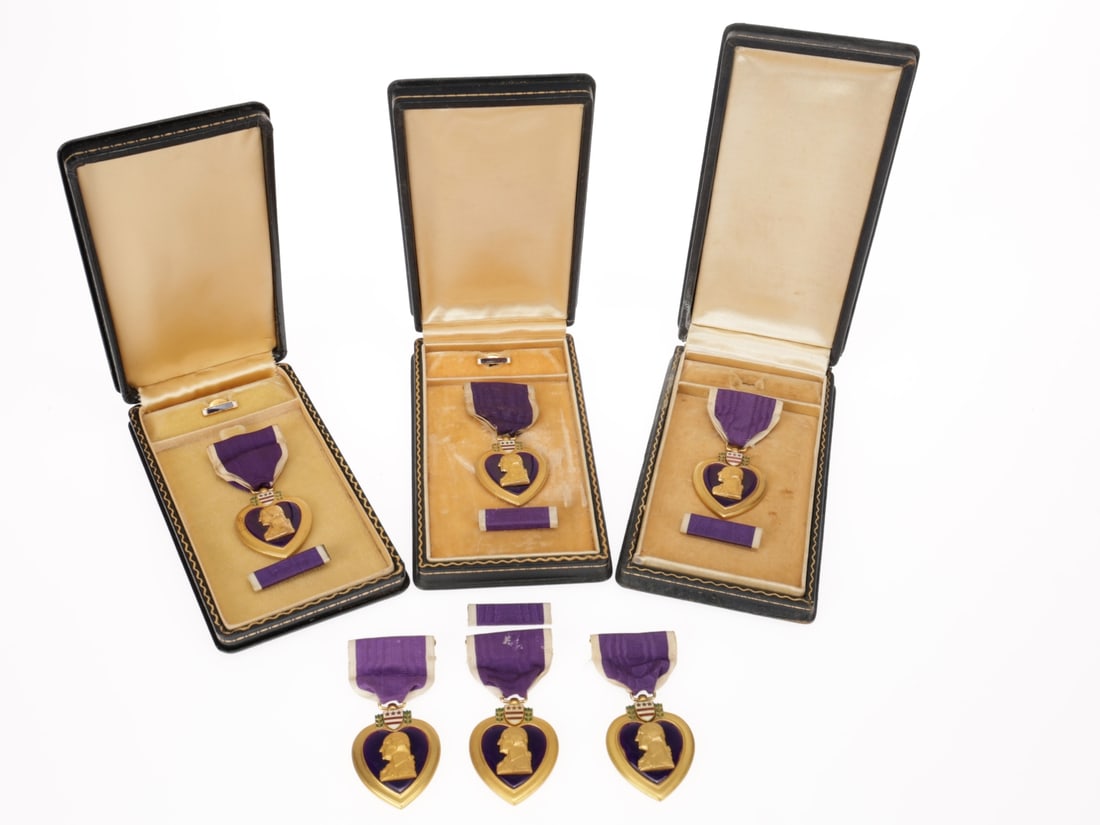 Purple Heart Medal Lot: Purple Heart Medal Lot. Lot of six Purple Heart medals: Two numbered slot-brooch Purple Heart medals, with enamel lapel button and ribbon bar, in black cases with tan plush interiors, no inscriptions 