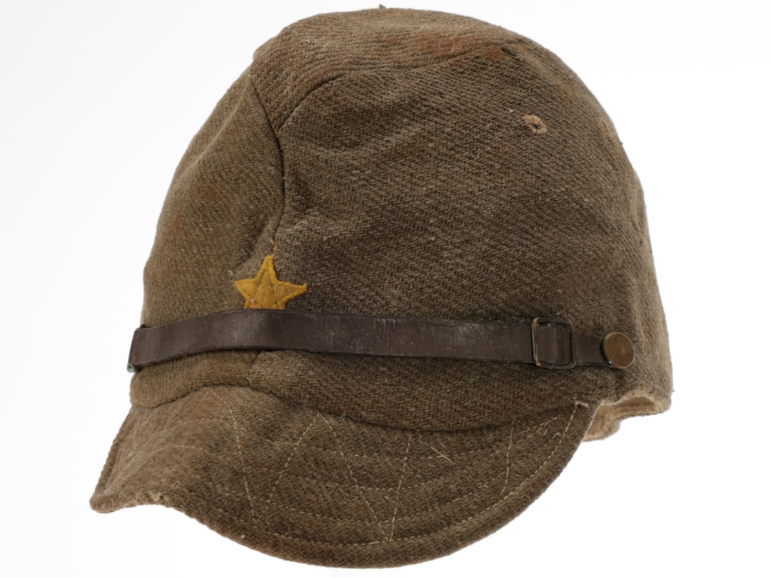 Japanese WWII Army Field Service Cap: Japanese WWII Army Field Service Cap Coarse olive wool field cap has short visor of the same cloth, brown pigskin leather adjustable chinstrap with small metal side buttons, obverse has applied yellow