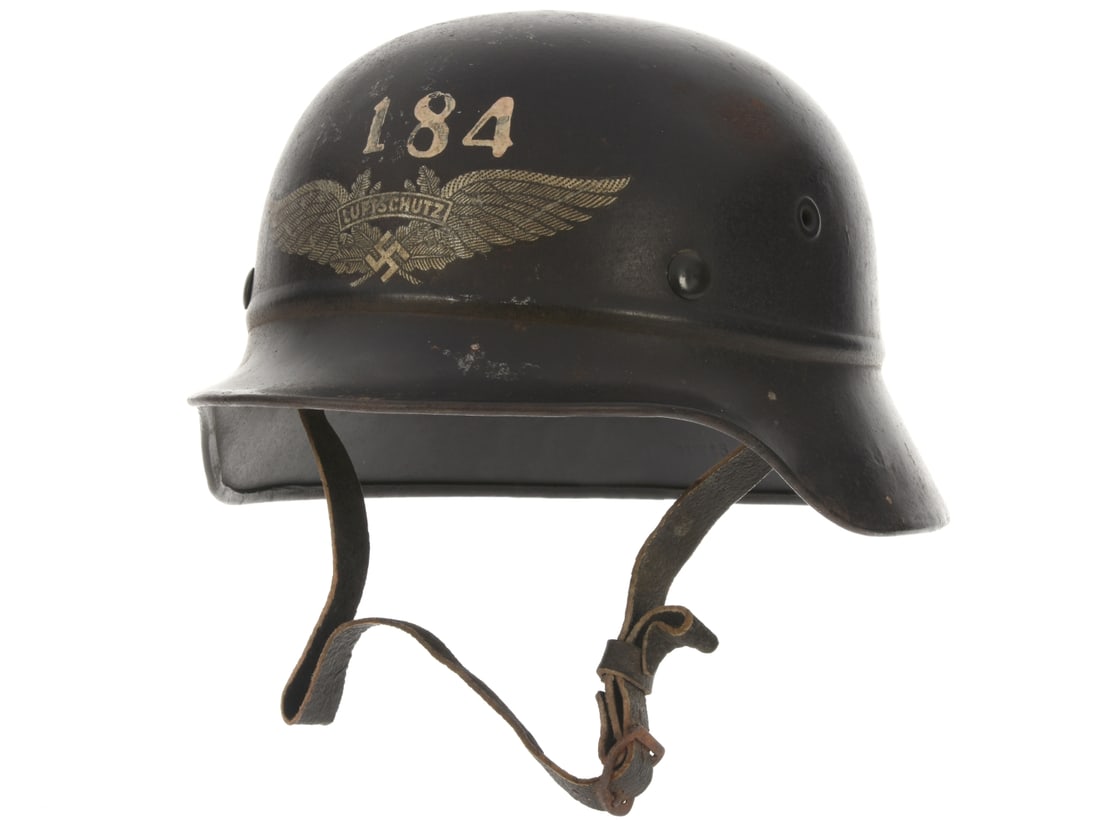 WWII German M40 Luftschutz Helmet: WWII German M40 Luftschutz Helmet The helmet shell is beaded where the crown meets the apron, has two stamped, single hole vents and a rolled edge. Exterior retains 80% blue-black finish and the numbe