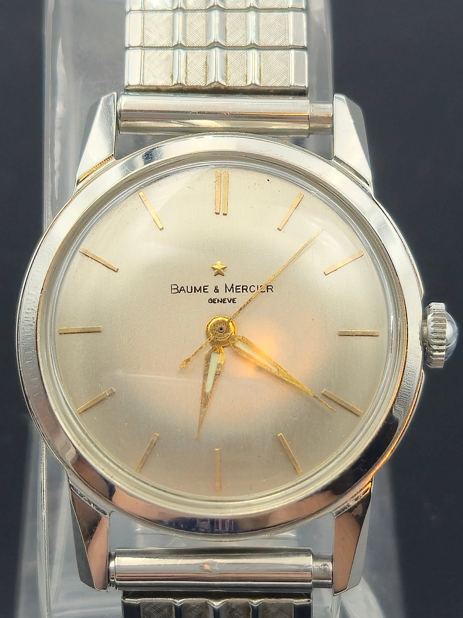 Vintage Baume & Mercier Genève 17 Jewel Manual Wind Watch – ETA 2390 Movement JB champion: This elegant vintage Baume & Mercier Genève features a clean silver dial with minimalist gold-tone baton markers and matching dauphine hands. Housed in a polished stainless steel case and powered by