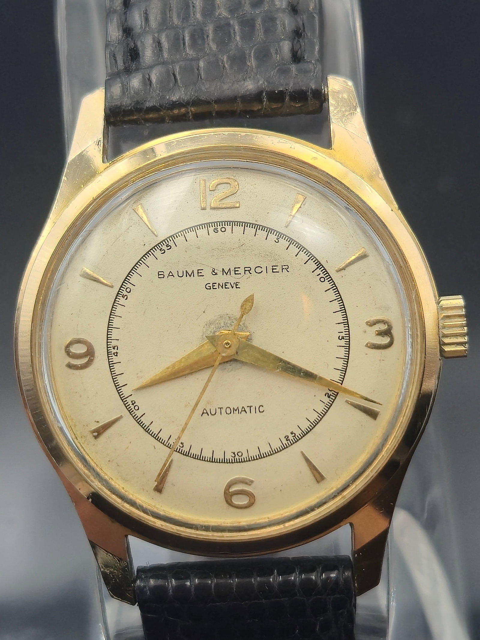 Vintage Baume & Mercier Genève Automatic – 17 Jewels, 10 Micron Gold Plated, Swiss Made: This elegant vintage Baume & Mercier Genève wristwatch features a classic mid-century design with a gold-plated case (10 micron) and stainless steel back, marked “Shock Resistant” and “Wate