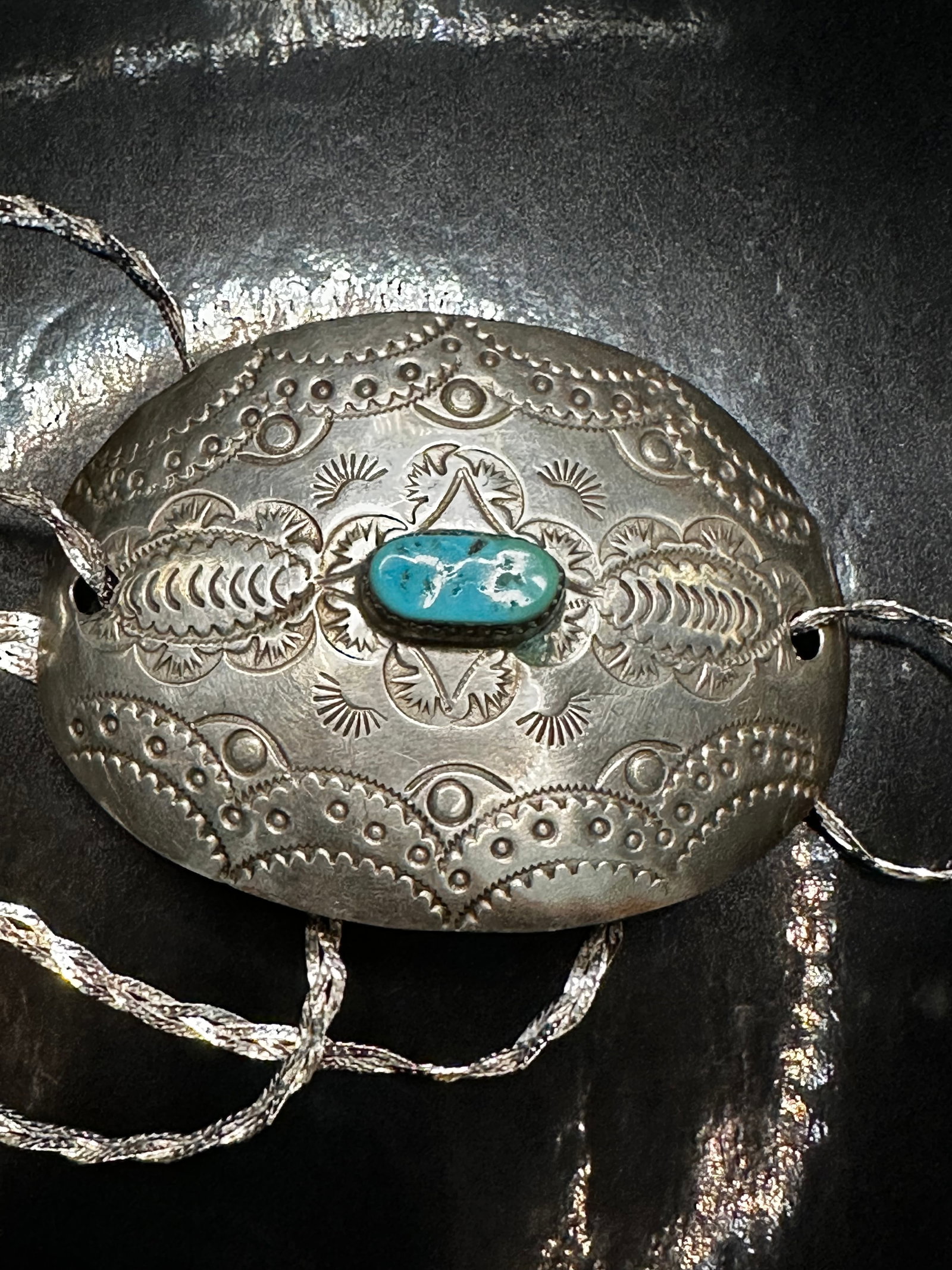 Vintage Navajo Sterling Silver & Turquoise Pendant Necklace: This striking vintage Navajo pendant necklace features a large, hand-stamped sterling silver concho pendant with intricate Southwestern designs and a central natural turquoise cabochon. The turquoise 