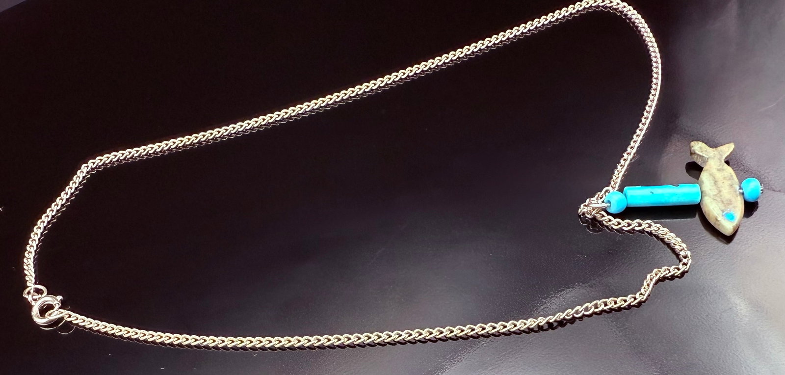 Zuni Sterling Silver Native American Turquoise fish Necklace: Sterling Silver chain necklace. This is a Zuni made design necklace. the chain is Sterling Silver with Turquoise stones on either side of the stone fish. The chain is 16’ could be changed out with a