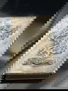 Antique Sterling Silver St. Nazaire Matchbox Holder – Art Nouveau Relief – 24.4g: This antique sterling silver matchbox holder features an elegant raised Art Nouveau-style relief of a robed female figure holding a garland, above a ribbon banner inscribed "St. NAZAIRE". Likely craft