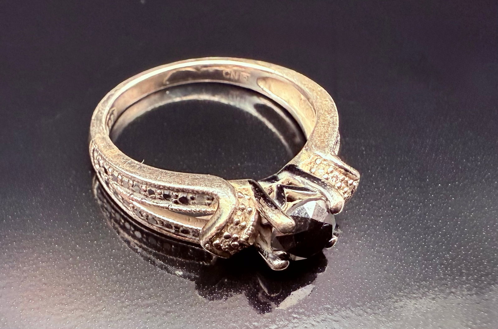 Sterling Silver Black Onyx Solitaire Stone with Solitaire Sparkly Stones Surrounding Size 7: This is a Solitaire Black Onyx center Stone with small sparkly black Onyx surrounding the main stone. Sterling Silver with a 925 stamped on the ring. The center Stone looks to be a total Ct. The ring 
