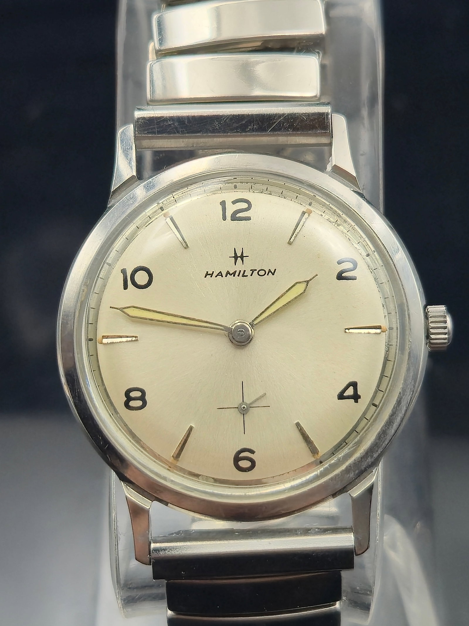 1960s Hamilton Manual Wind Stainless Steel Watch | 35mm Calatrava Style Dial: This vintage 1960s Hamilton wristwatch features a clean and classic Calatrava-style dial with a smooth silver-tone finish, alternating Arabic numerals and indices, and a recessed sub-seconds register 