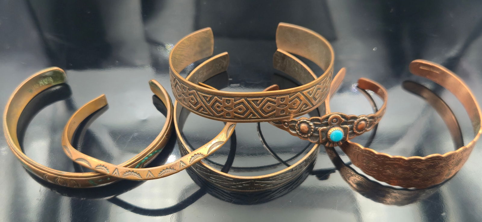 Vintage 68.8g Copper Bracelet Lot – Solid Copper, Nakai & Southwestern Turquoise Thunderbird: Lot of 5 vintage copper cuff bracelets, total weight 68.8 grams. Includes a Solid Copper Thunderbird cuff with turquoise cabochon, a Nakai signed Native American–style cuff with stamped and enameled