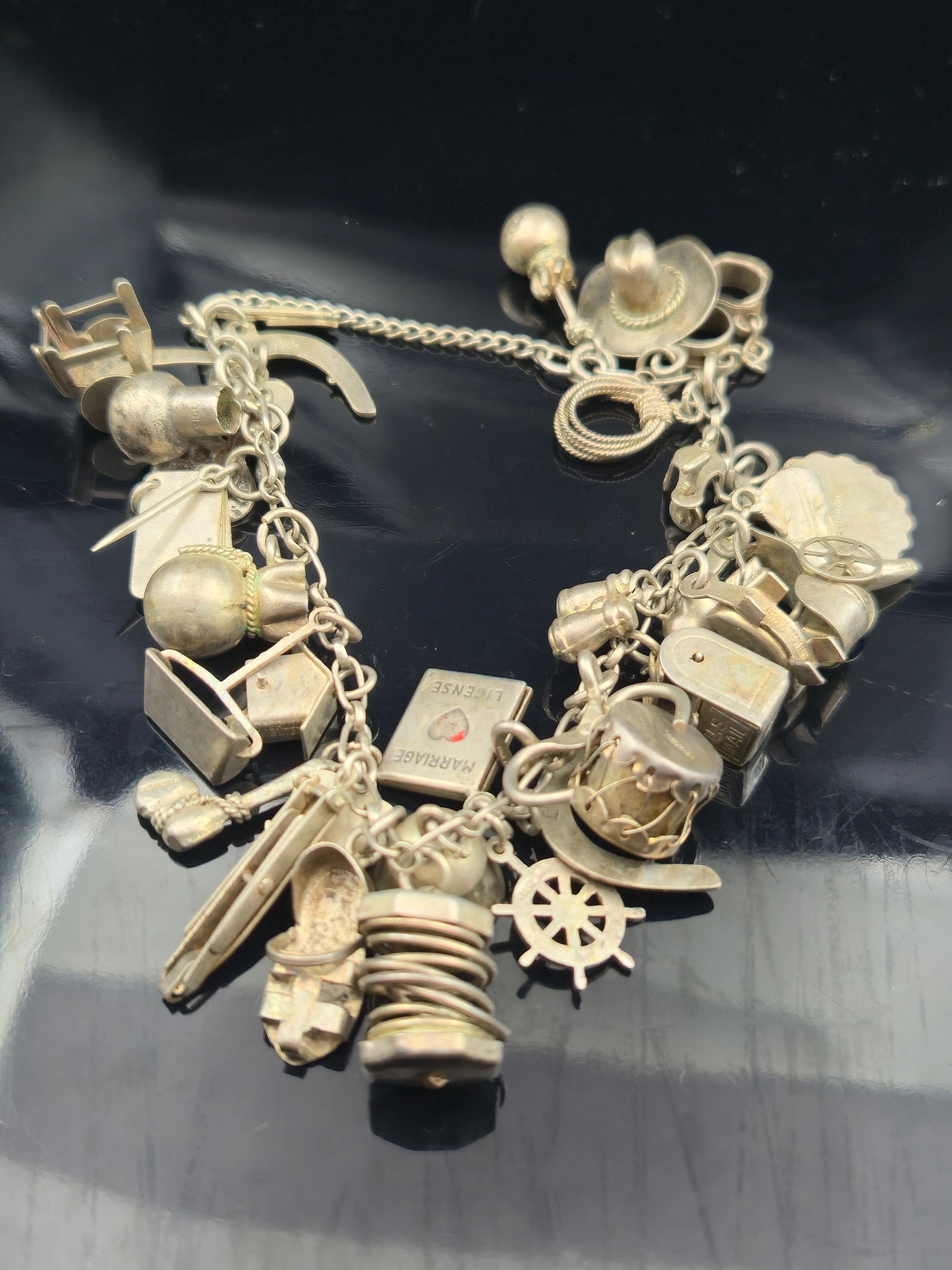 Vintage Sterling Silver Charm Bracelet, 30+ Charms, 48.1g: A vintage sterling silver charm bracelet loaded with over 30 individual sterling charms, weighing a total of 48.1 grams. Charms include Western and novelty themes such as a cowboy hat, horseshoe, pist
