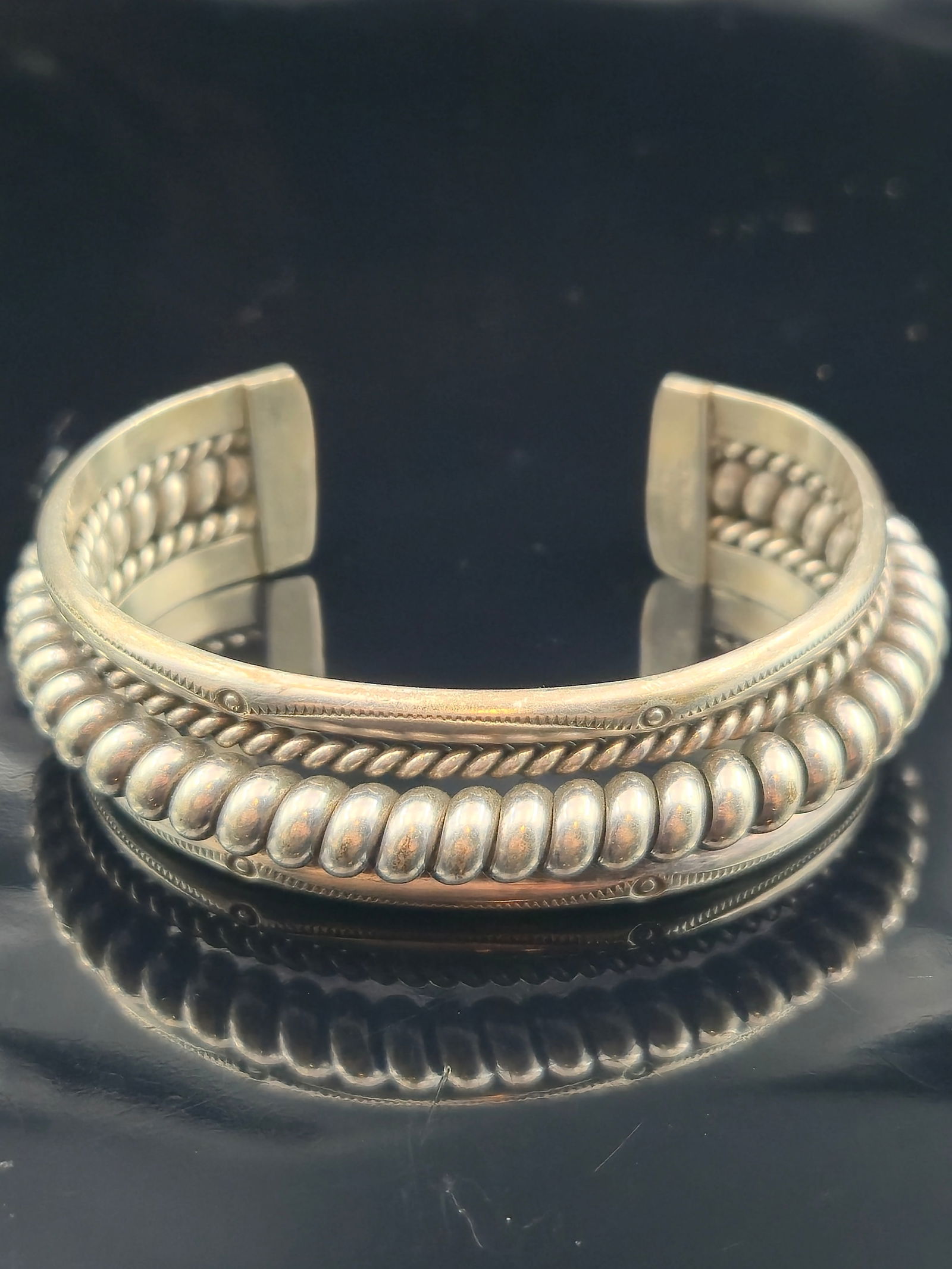 Navajo Jahe Sterling Silver Heavy Cuff Bracelet, 58.1g: Handmade Native American Navajo sterling silver cuff bracelet by Jahe. The bracelet is crafted in heavy-gauge sterling with a bold repoussé bead center row, bordered by twisted wire and stamped detai