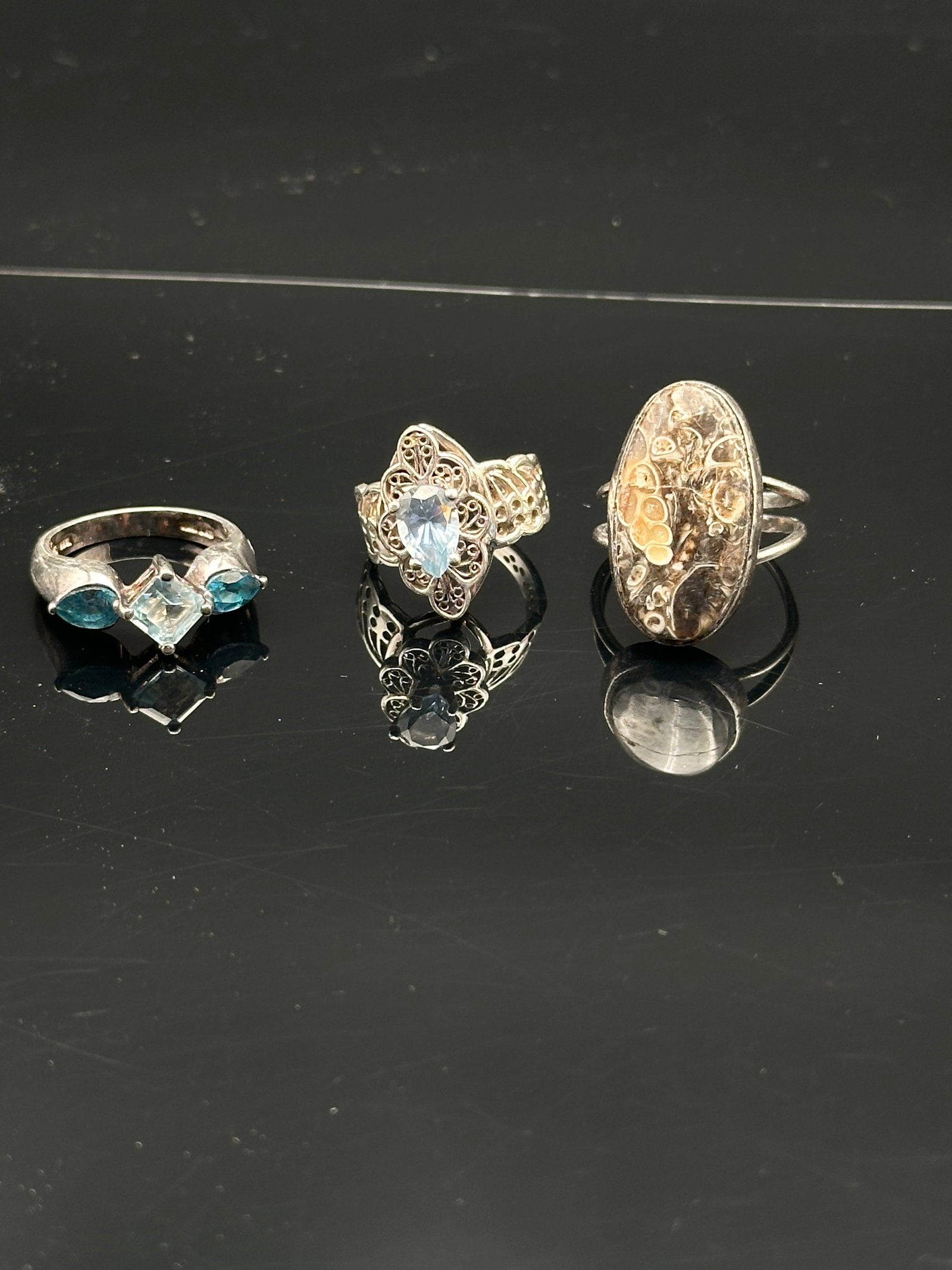 Set of Three Sterling Silver Rings – Blue Topaz, Filigree, and Vintage Oval Design: Elegant collection of sterling silver rings featuring gemstone accents and intricate artistry:•Blue Topaz Trio Ring: Sterling silver band set with a central square-cut blue topaz, flanked by two