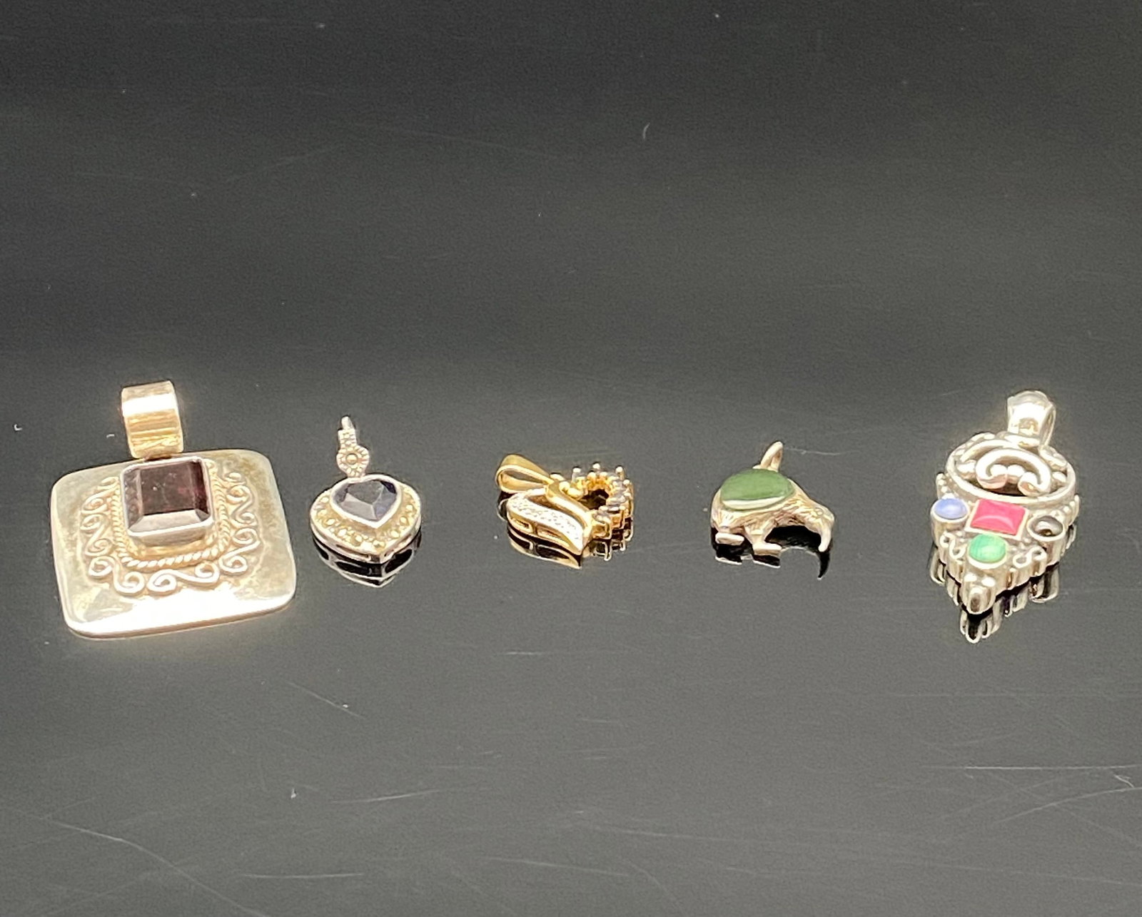 Sterling Silver & Mixed Metal Pendants: A charming collection of unique pendants, each with distinct design and character:1.Square Garnet Pendant – Bold sterling silver square pendant with intricate scrollwork and a deep red garnet center