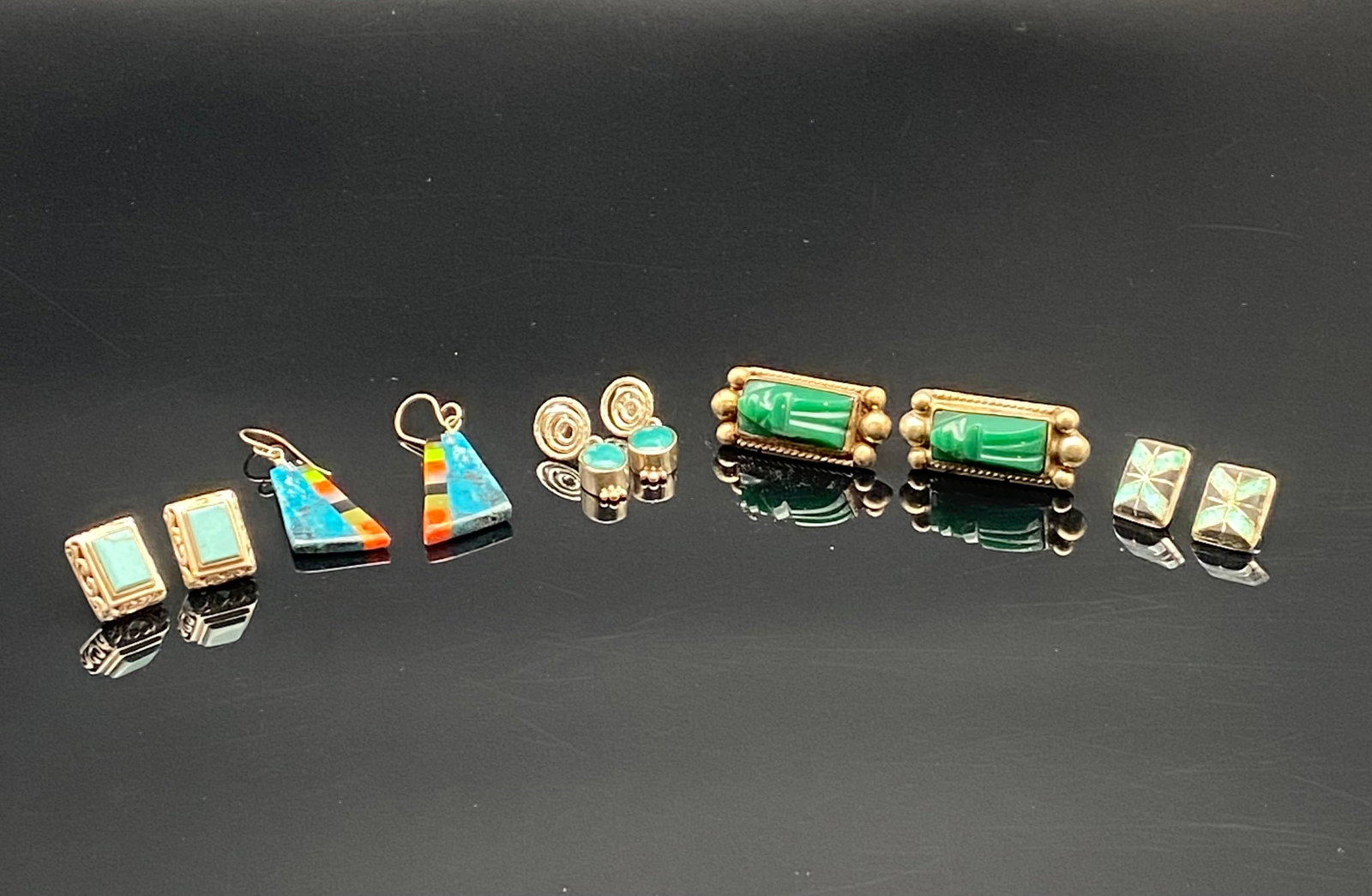 Sterling Silver Earrings with Turquoise & Inlay Designs: A striking collection of five pairs of sterling silver earrings, featuring turquoise, inlay, and carved stone accents:•Far Left: Rectangular turquoise stud earrings framed in ornate silver settin