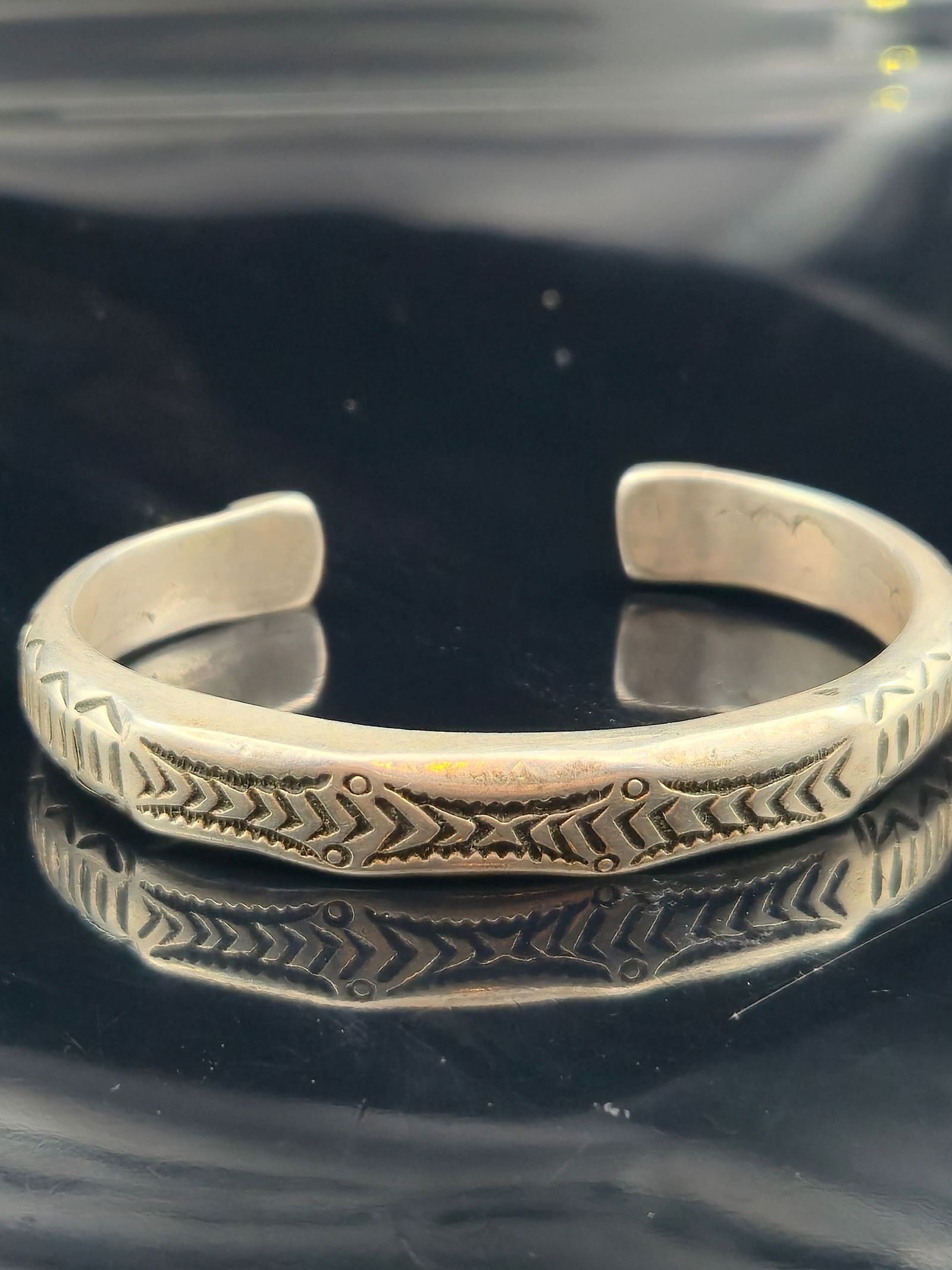 Vintage Sterling Silver Southwestern/Mexican Stamped Cuff Bracelet, 50g: A vintage sterling silver cuff bracelet, mid-20th century, with bold hand-stamped chevron and geometric designs along the band, finished with sunburst motif end caps. Style is consistent with Southwes