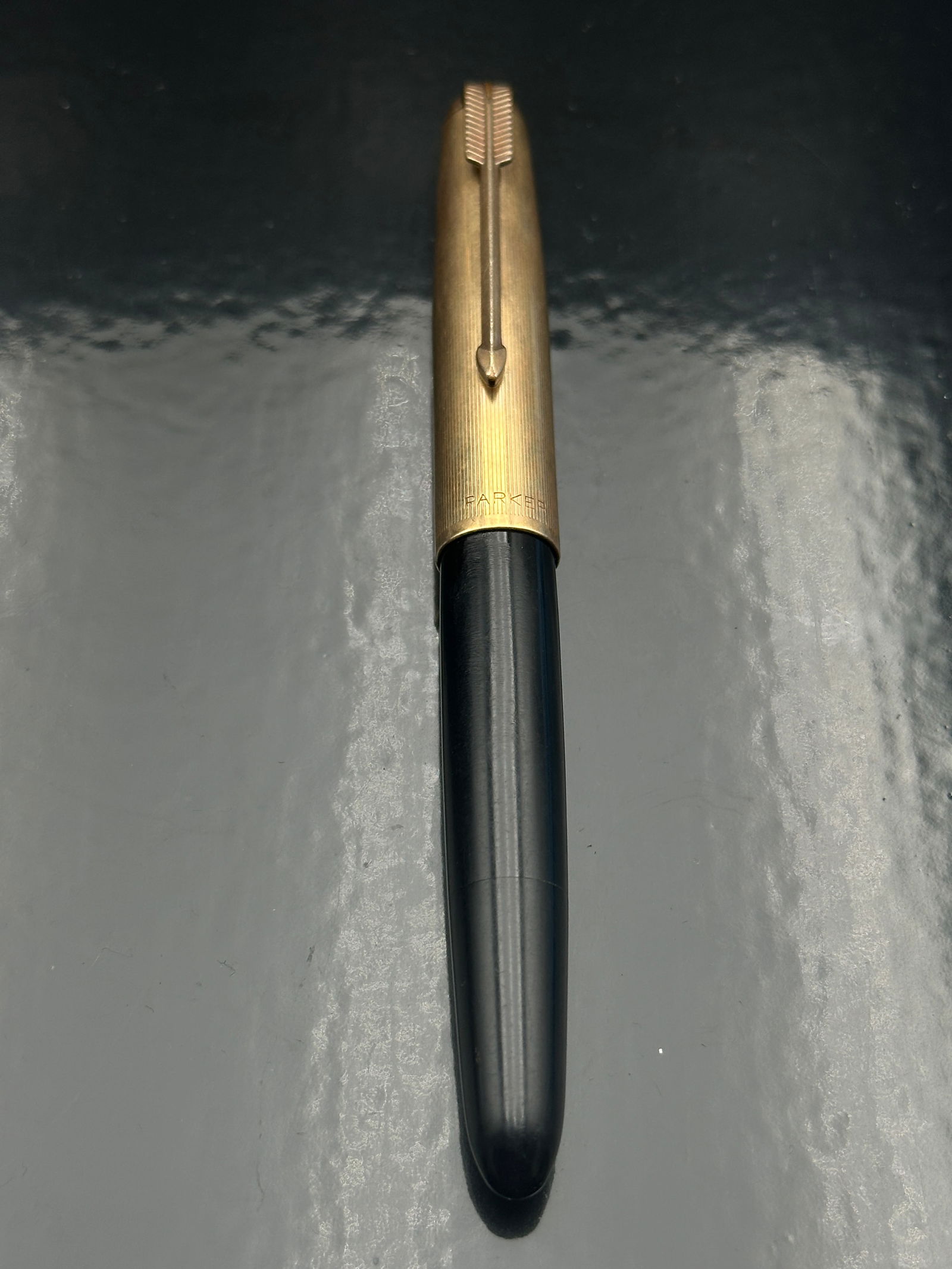 Vintage Parker 51 Demi Fountain Pen – Black Resin with Gold-Filled Cap & Arrow Clip: A vintage Parker 51 Demi fountain pen, introduced in the late 1940s as a slightly shorter, slimmer version of the iconic Parker 51. This example features a smooth black resin barrel and a gold-filled