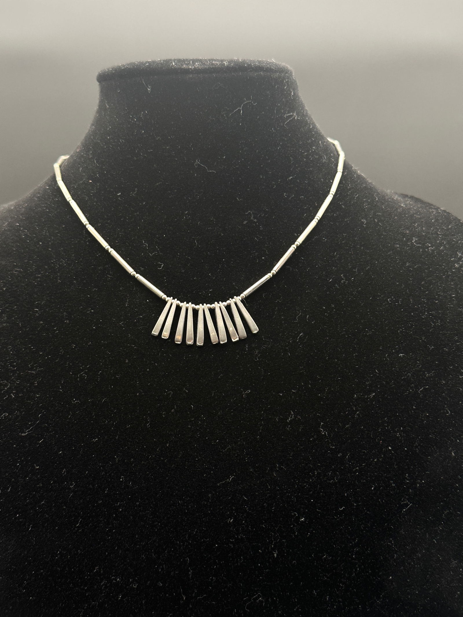 Vintage Sterling Silver Modernist Necklace with Dangling Bar Pendants: A striking vintage sterling silver necklace featuring a series of graduated rectangular bar pendants suspended from a beaded strand. The sleek, geometric design gives this piece a bold modernist flair