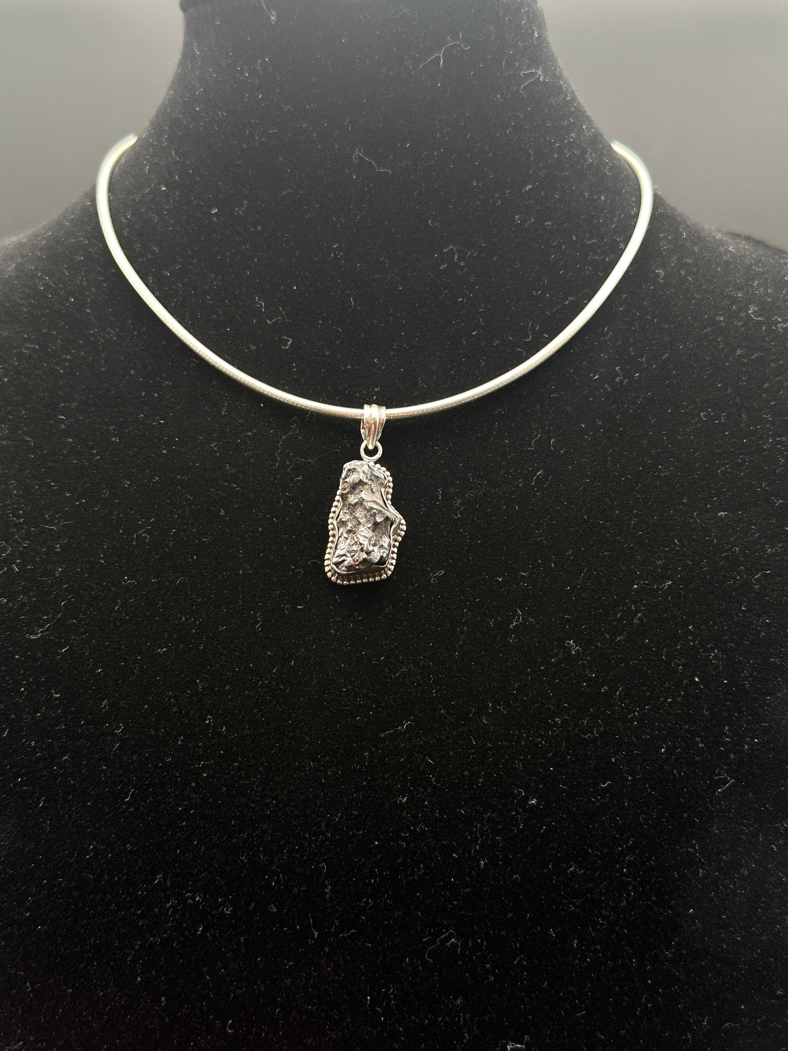 Sterling Silver Nugget-Style Pendant Necklace with Collar: Modern sterling silver necklace featuring a striking nugget-style pendant with naturalistic texture, framed in a beaded silver border. The pendant hangs from a polished collar-style necklace, creating