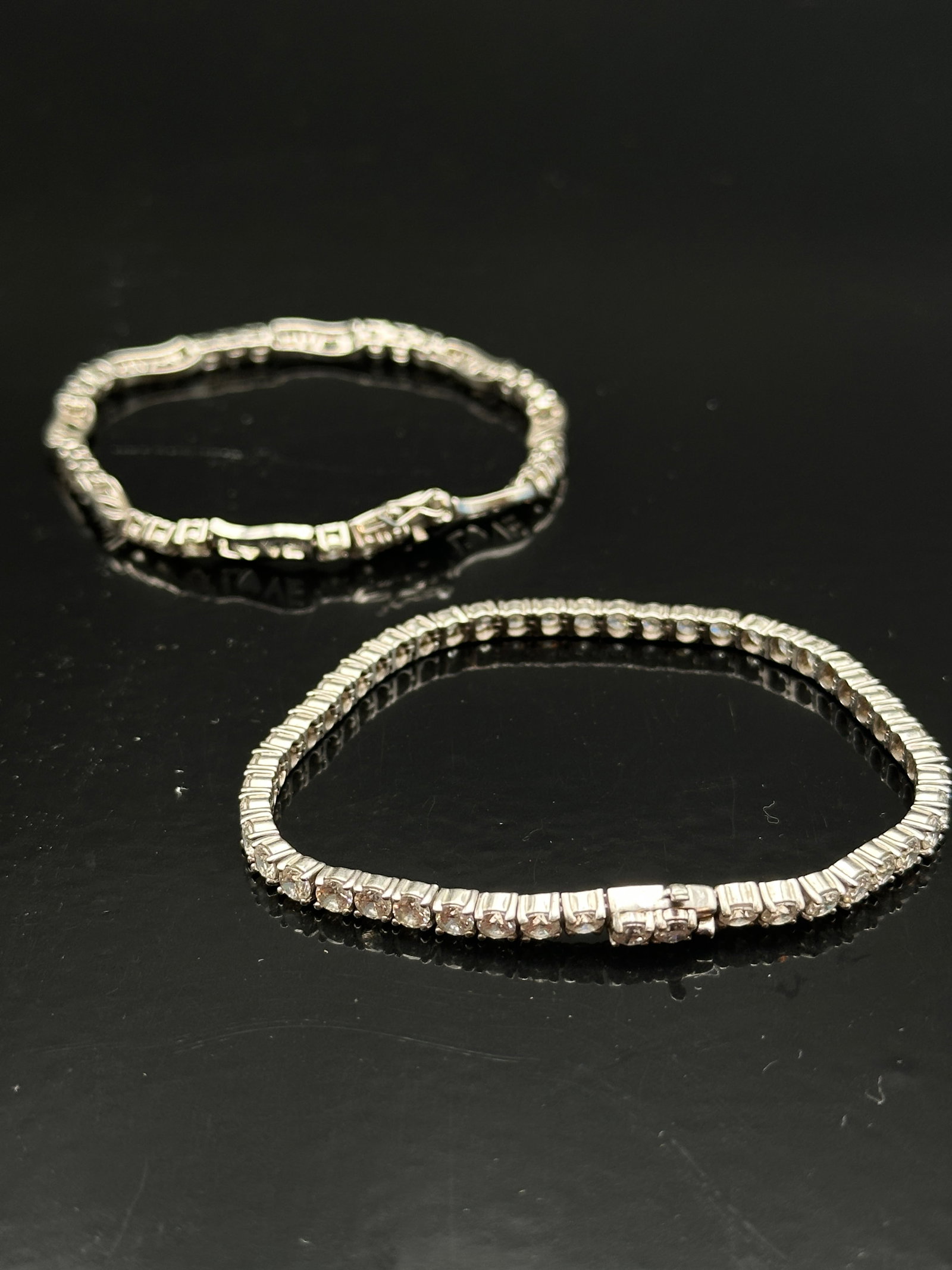 Lot of Sterling Silver 925 Cubic Zirconia Tennis Bracelets: Elegant pair of sterling silver tennis bracelets featuring sparkling cubic zirconia stones. Both bracelets are finely crafted in classic line-link design, offering a timeless and versatile style suita