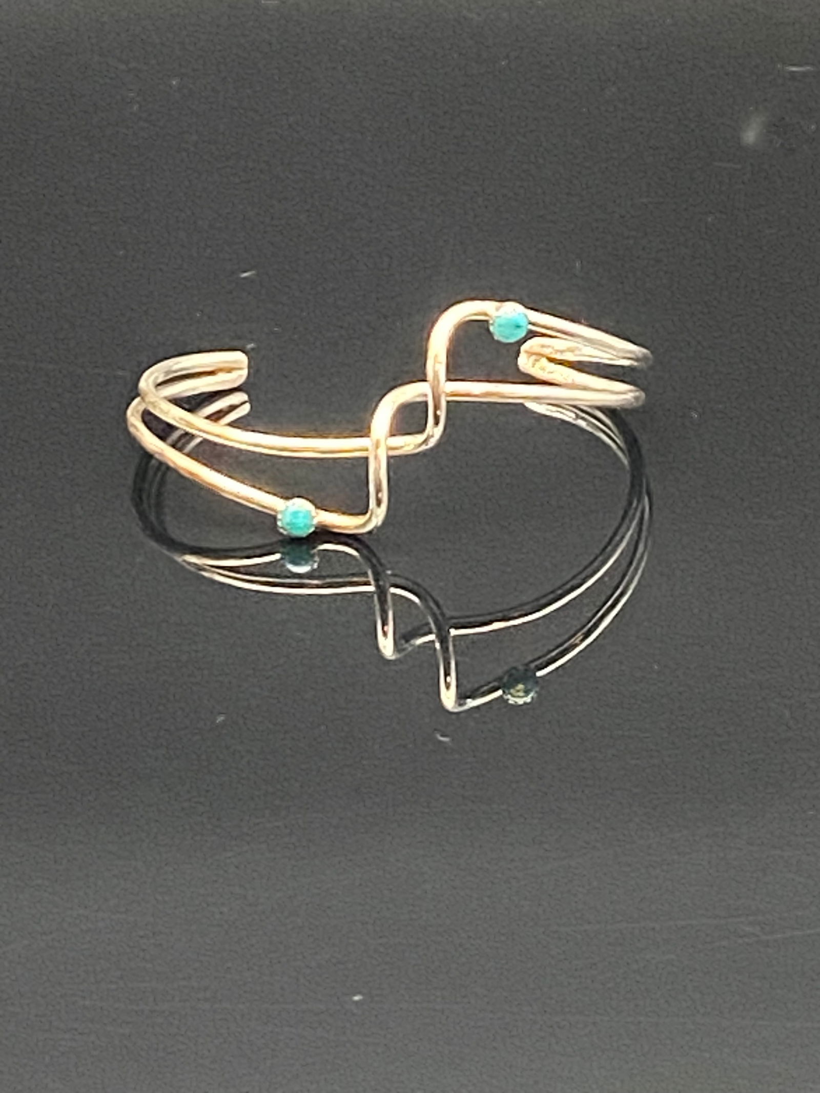Modernist Sterling Silver Cuff Bracelet with Turquoise Accents: A sleek and artistic sterling silver cuff bracelet featuring an open, freeform modernist design. The bracelet is accented with four small round turquoise cabochons, each placed at the intersections of