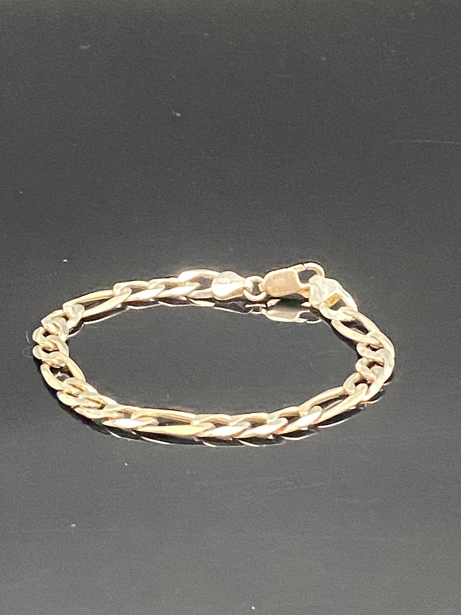 Italian Sterling Silver 925 Figaro Chain Bracelet: A classic Figaro chain bracelet crafted in Italy from genuine sterling silver, stamped “925” on the clasp. The bracelet has a polished finish with a warm golden tone, likely gold-plated over s