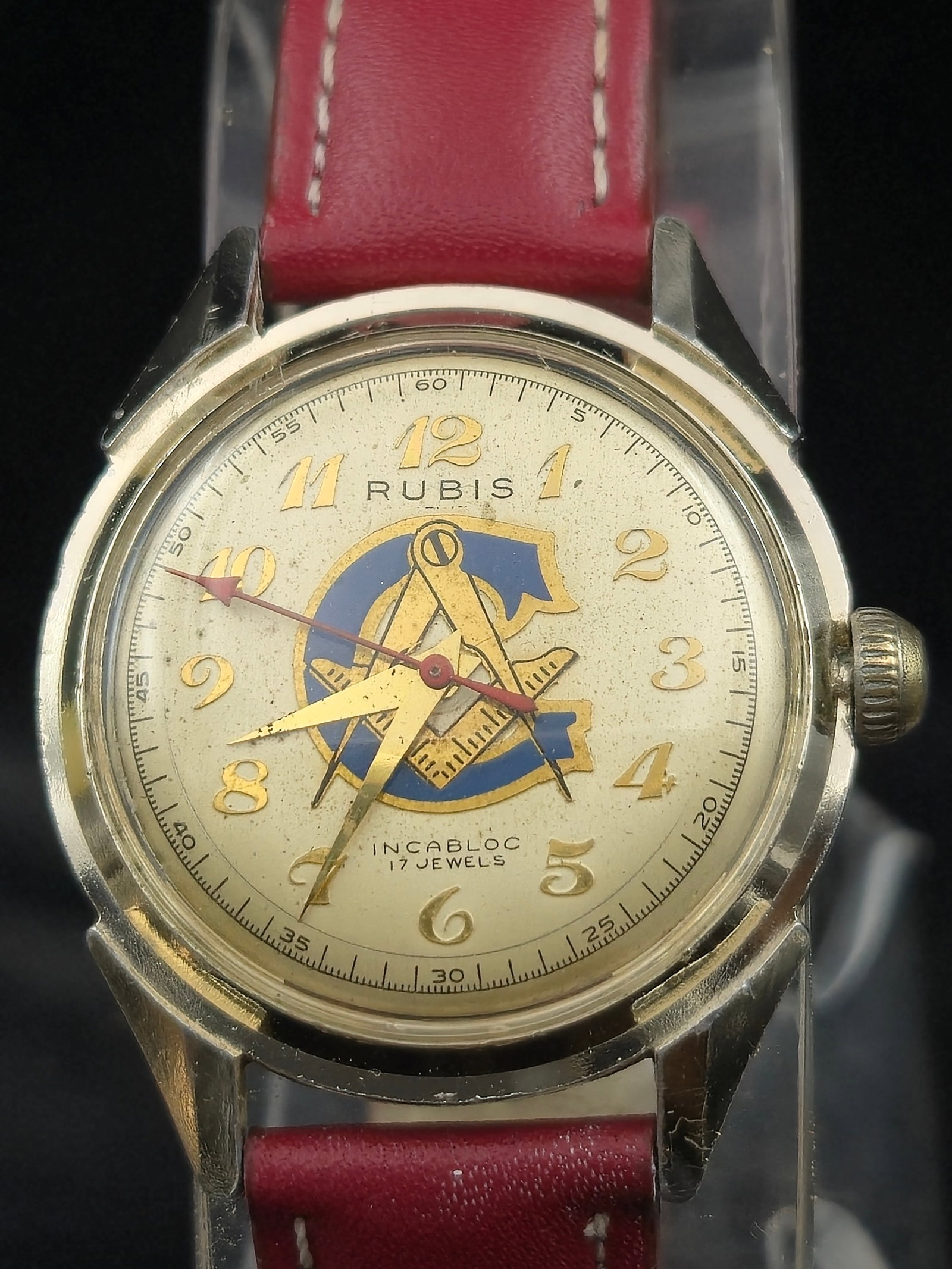 Rubis Masonic 17J Swiss Incabloc Wristwatch, Compass & Square Dial, 34mm: Vintage Swiss Masonic wristwatch by Rubis. Gold-tone case, stainless back marked Waterprotected – Carbloc – Antimagnetic – 10-93. Cream dial with blue/gold Square & Compasses (G) emblem, gilt Ar