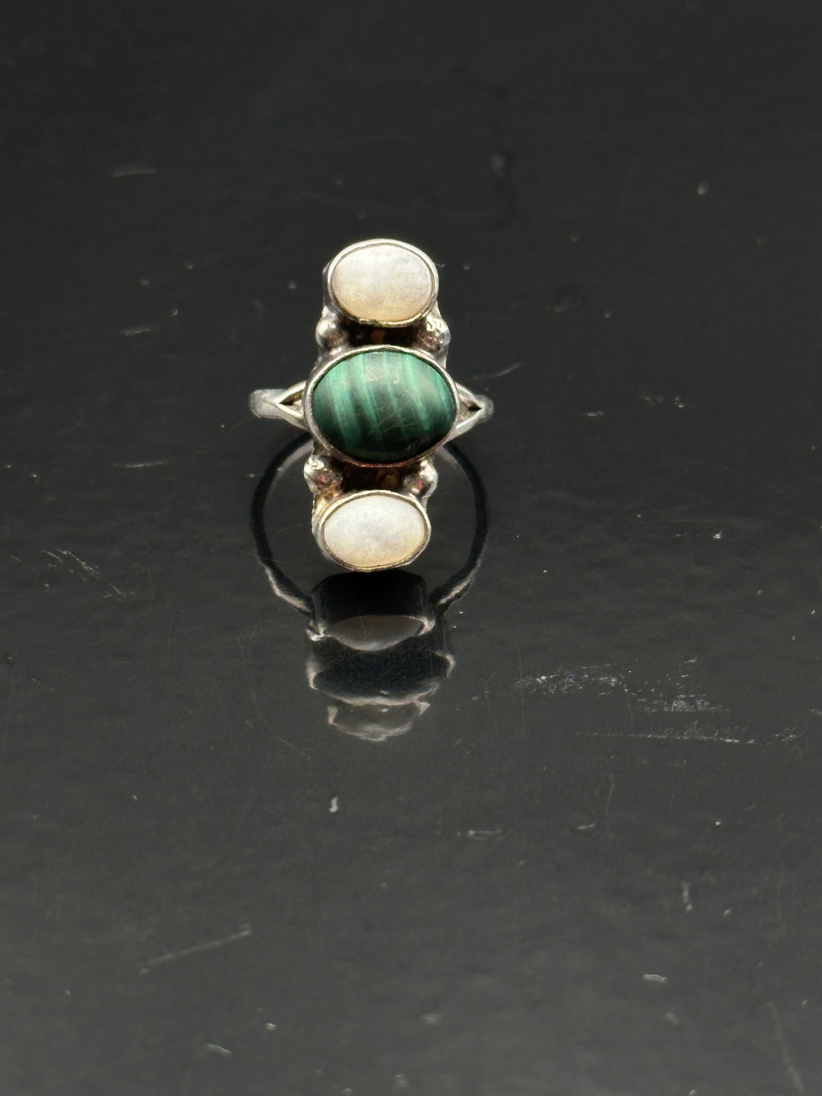 925 Sterling Silver Malachite & Mother of Pearl Ring: A striking sterling silver ring featuring two contrasting gemstones: a rich green oval malachite cabochon with natural banding and a luminous white mother of pearl cabochon. The stones are bezel-set a