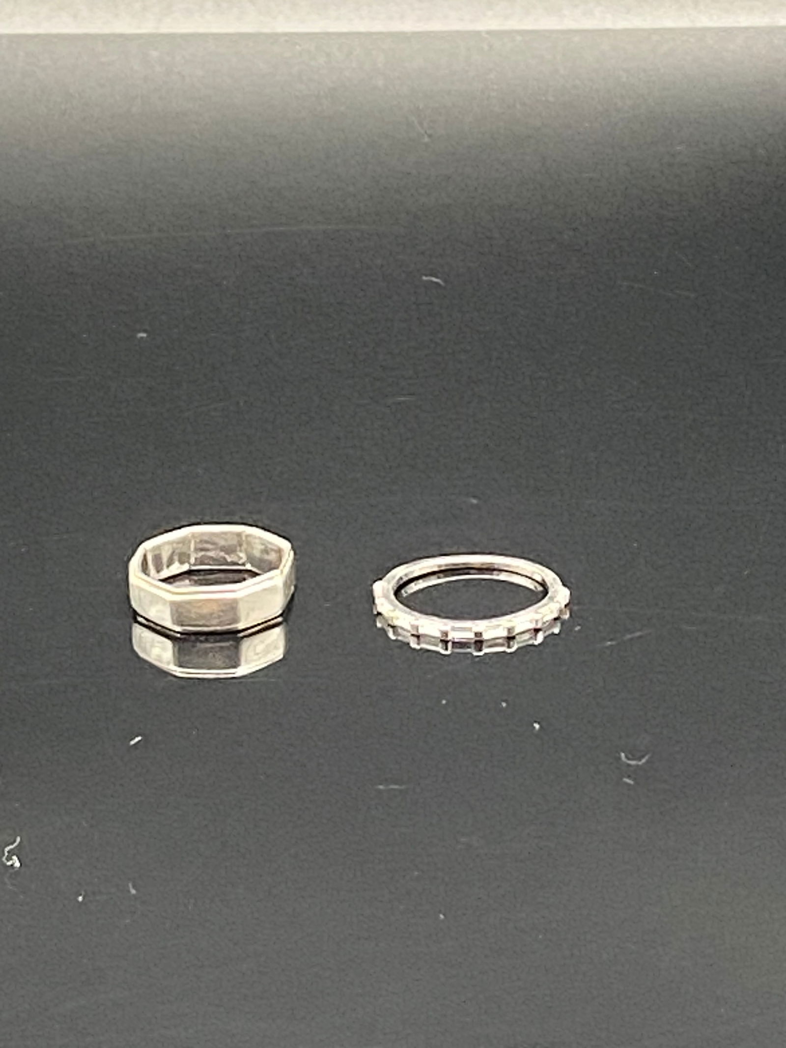 Set of 2 Sterling Silver Rings: Pair of vintage sterling silver rings, total weight 5.31 grams. One is an octagon-shaped band, size 5.75, and the other is a slim ring with raised settings, size 8. Both have a minimalist geometric st
